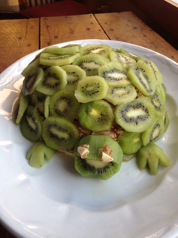 A healthy birthday cake made from sliced kiwis and bananas. Called a Turtle Cake due tot he shape of it and the kiwi shell.