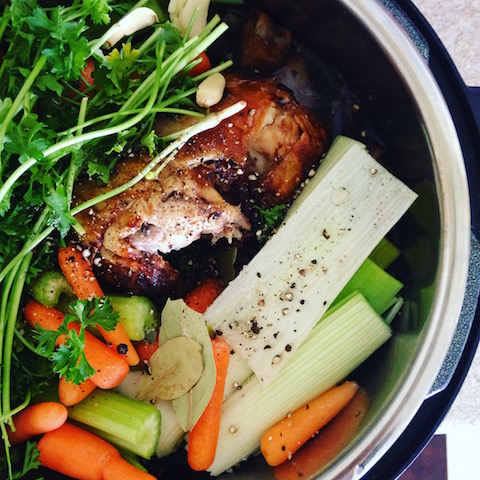 All it takes to make real bone broth is to fill a pot with the ingredients in this photos: chicken, parsley, celery, carrots, onions, vinegar, salt and pepper and let it simmer for 24 hours. 